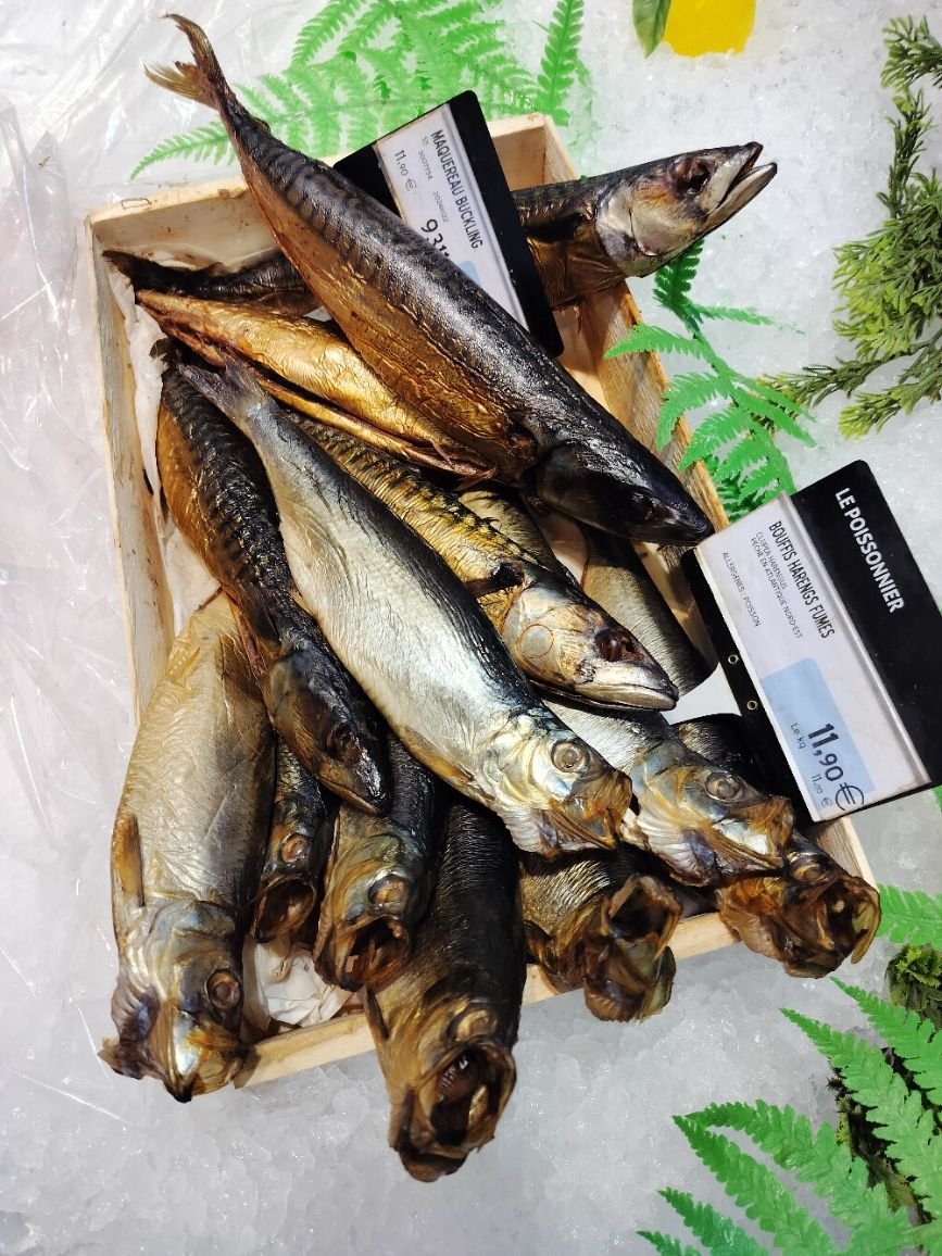 Poissons harengs fumés dans une boîte en vente dans un marché photo gratuite