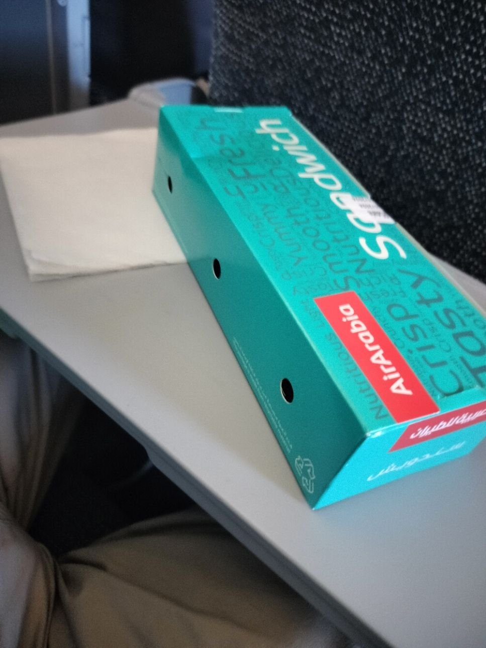 Boite en carton d'un sandwich Air Arabia sur une tablette photo gratuite