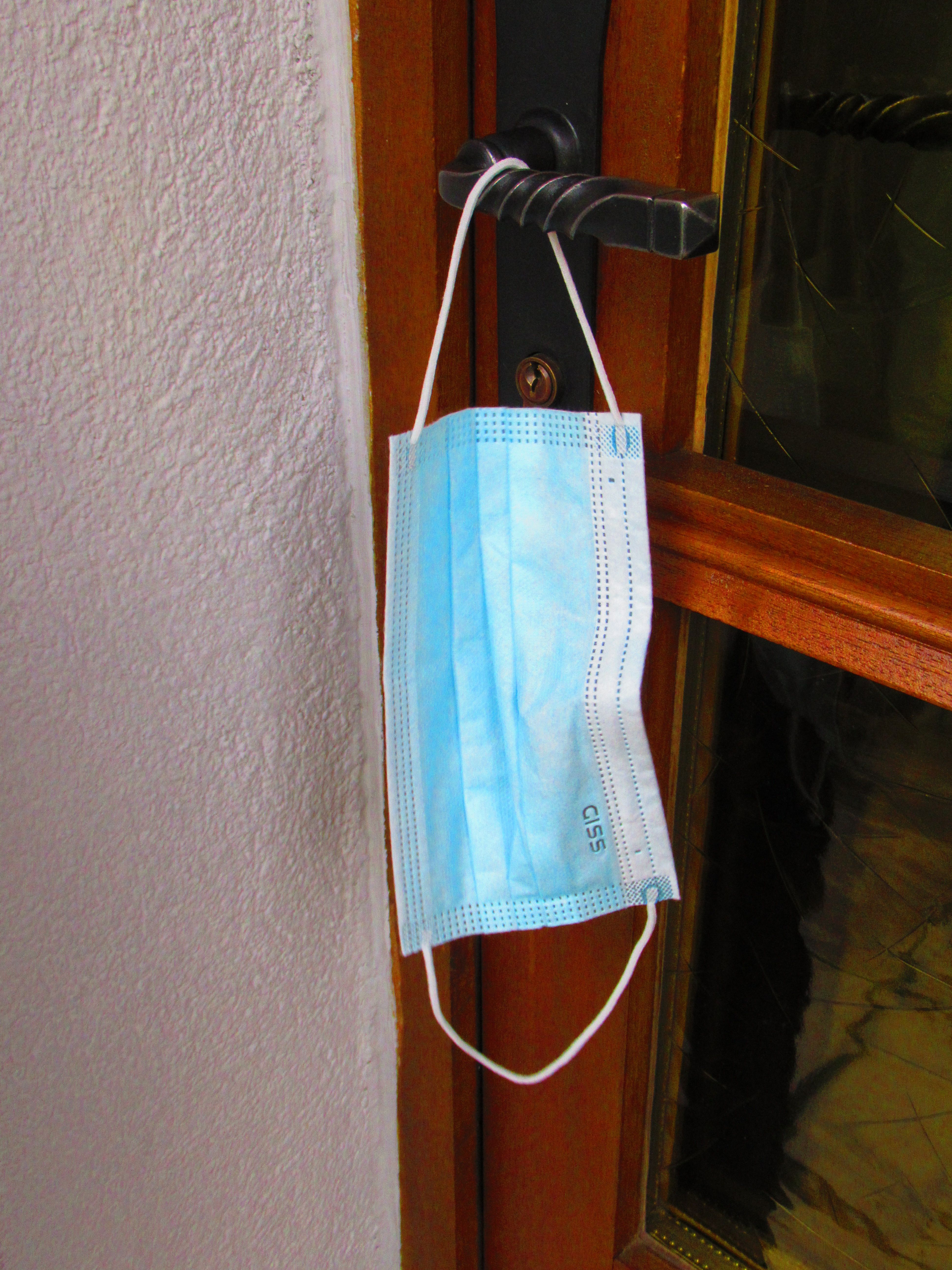 Sanitary mask hanging on a door handle