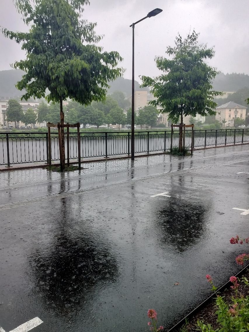 Une rue mouillée avec de la pluie tombant, photo gratuite