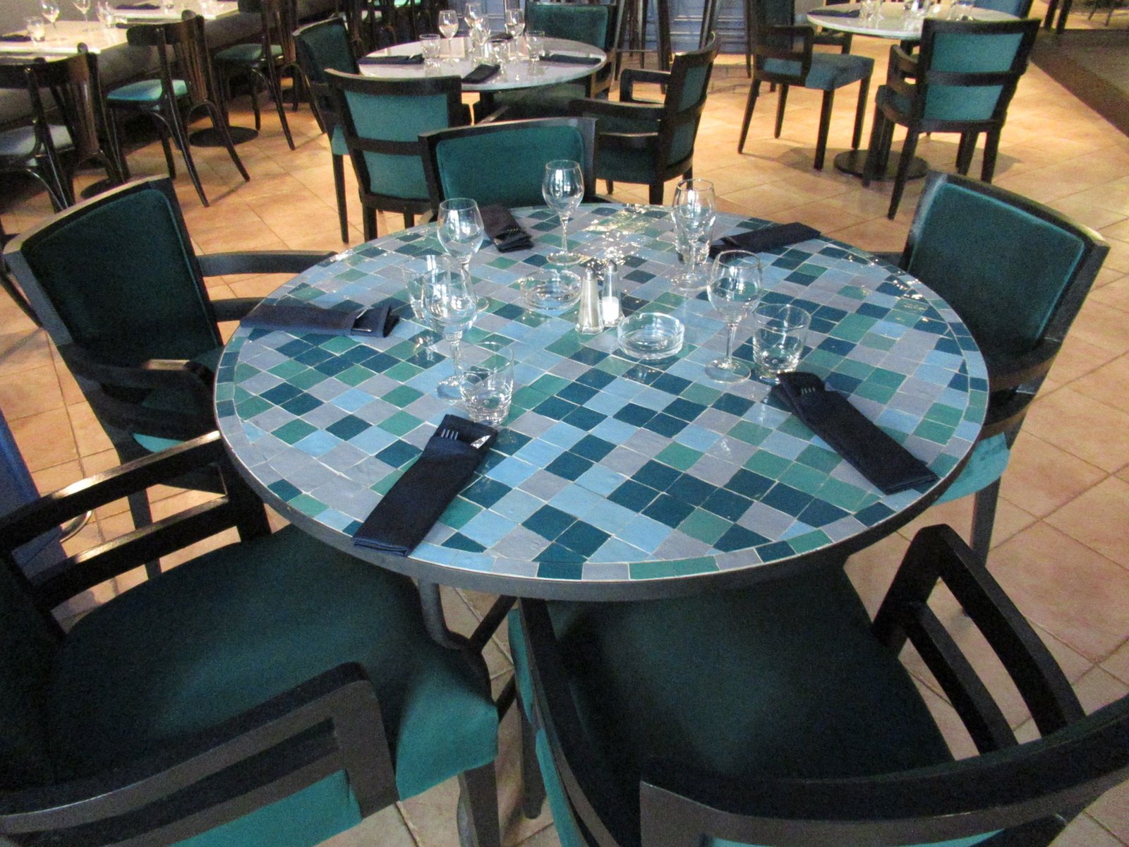 Intérieur d'un restaurant avec des tables rondes en mosaïques