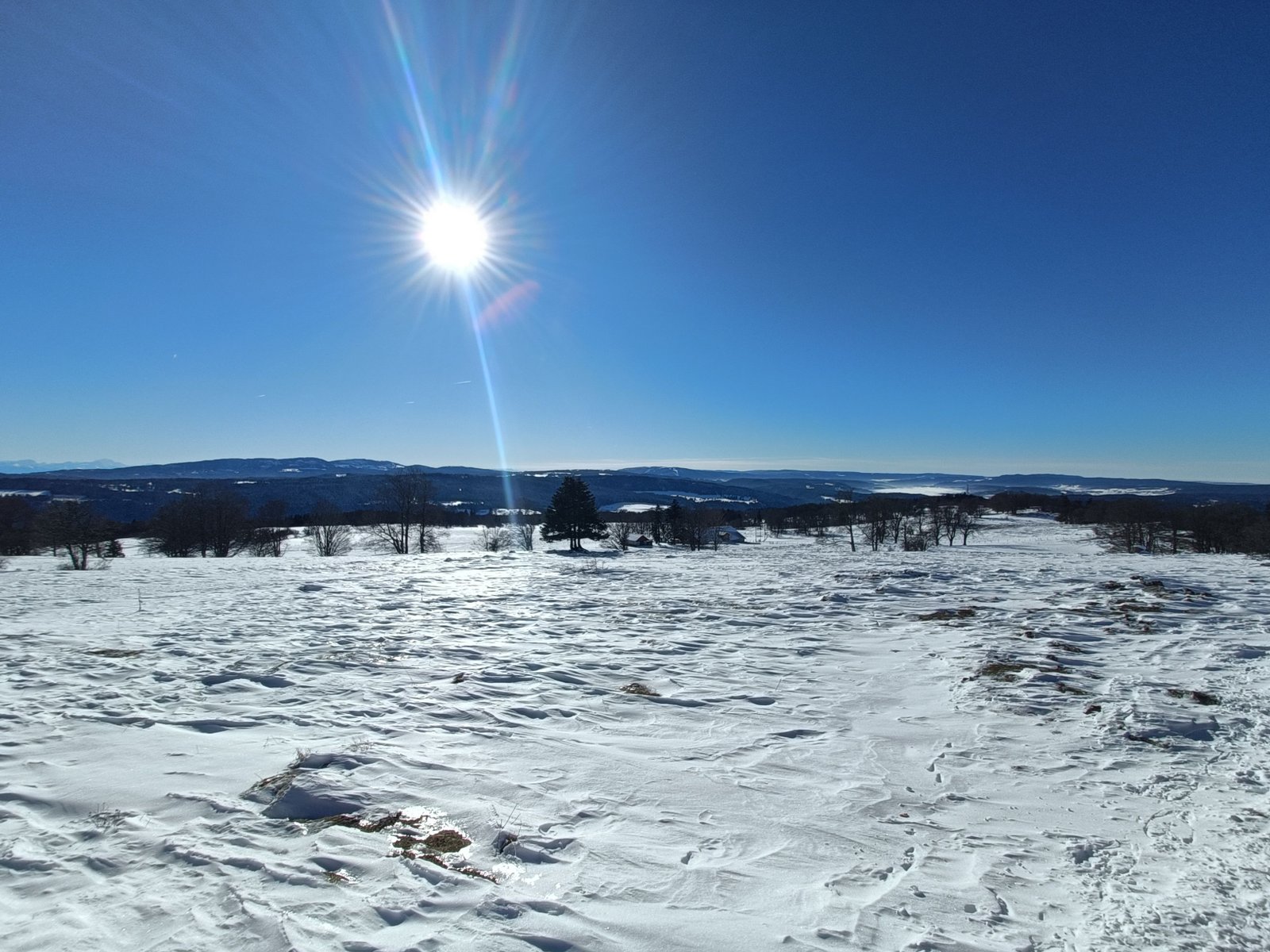 Un paysage de montagne enneigé sous un ciel bleu et ensoleillé, photo gratuite