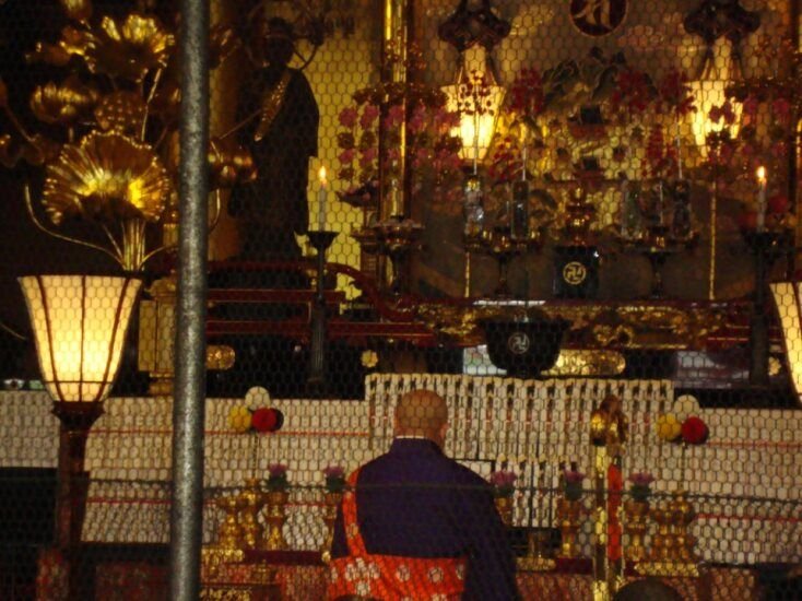 Moine en prière dans un temple bouddhiste photo gratuite