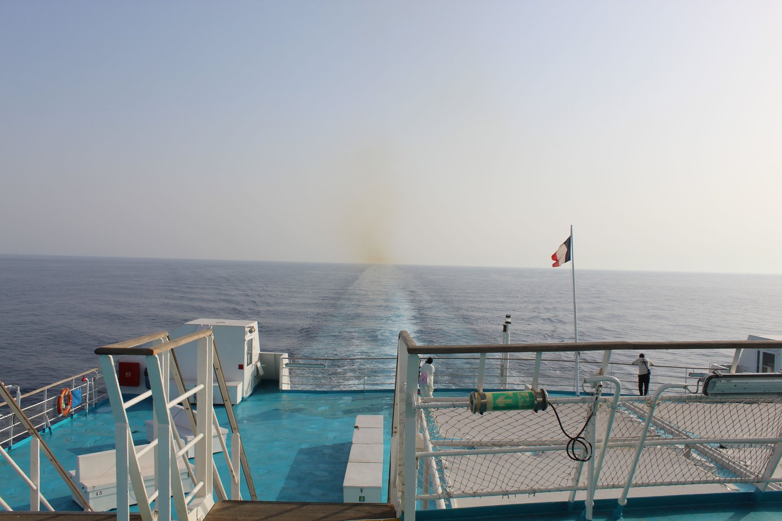 La poupe d'un navire en mer. On peut voir le sillage du navire s'étendant à l'arrière, ainsi qu'un drapeau français flottant, photo gratuite