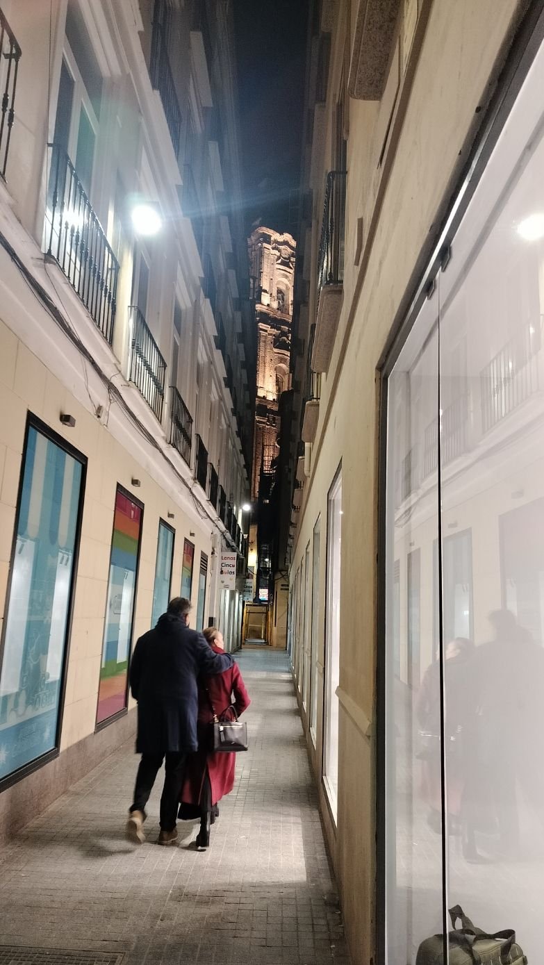 Deux personnes marchant dans un espace étroit bordé de bâtiments, photo gratuite