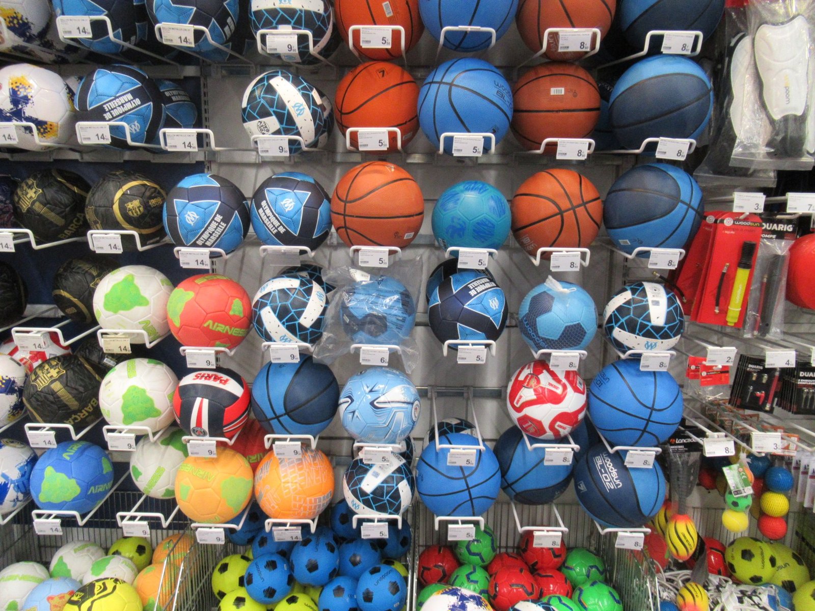 Ballons de sport exposés dans un magasin, incluant des ballons de football, de basket-ball et de volley-ball, photo gratuite