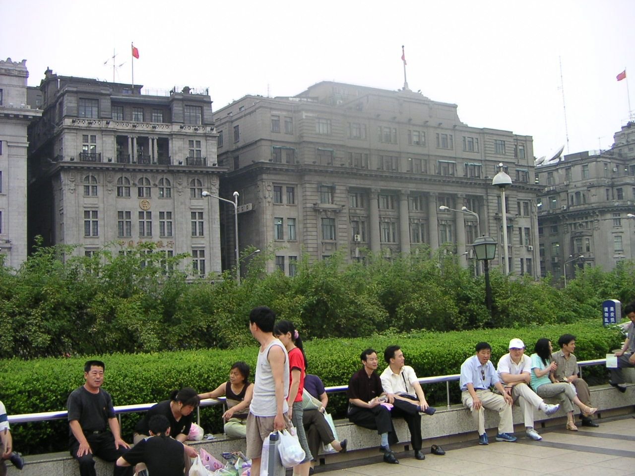Des personnes assises devant le batiment Bund Riverside, patrimoine colonial européen, monument du centre de la ville de Shanghai Chine, Asie photo gratuite