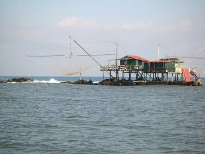 Une cabane de pêche traditionnelle en bois construite sur des pilotis, typique de la Bocca d'Arno à Marina di Pisa, en Italie, photo gratuite