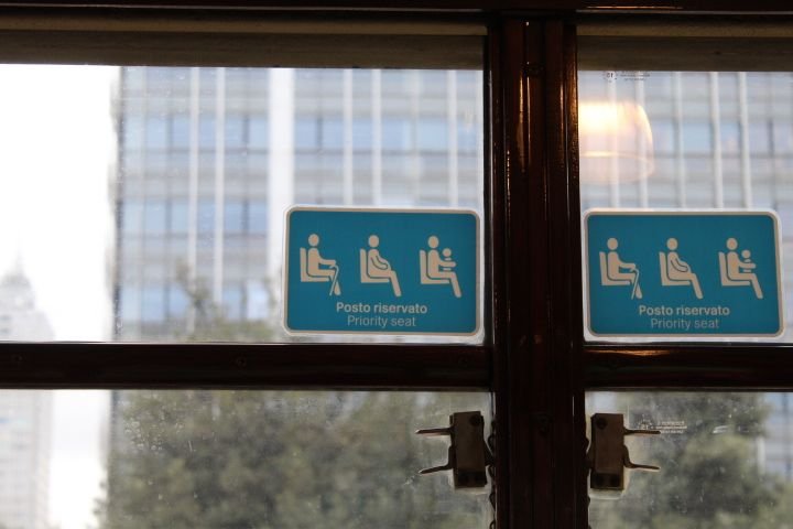 Etiquettes collés à la vitrine, panneaux d'obligation à céder la place aux prioritaires dans un transport dans la ville de Milan Lombardie en Italie photo gratuite