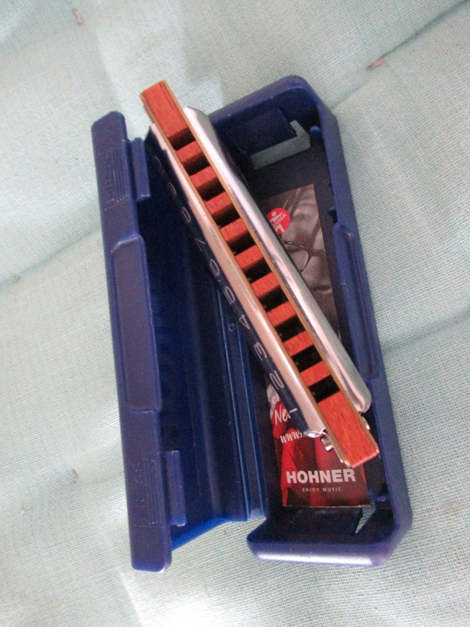 Hohner harmonica with its blue case