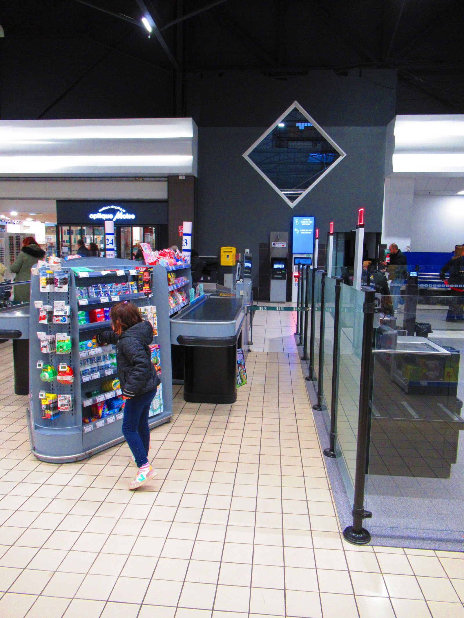 Jeune fille devant le rayon bonbons d'un supermarché photo gratuite