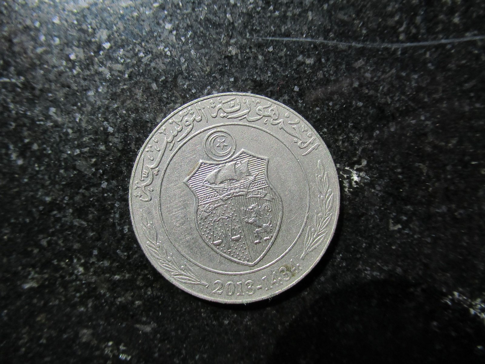 Face d'une pièce de monnaie tunisienne d'une valeur de un dinar