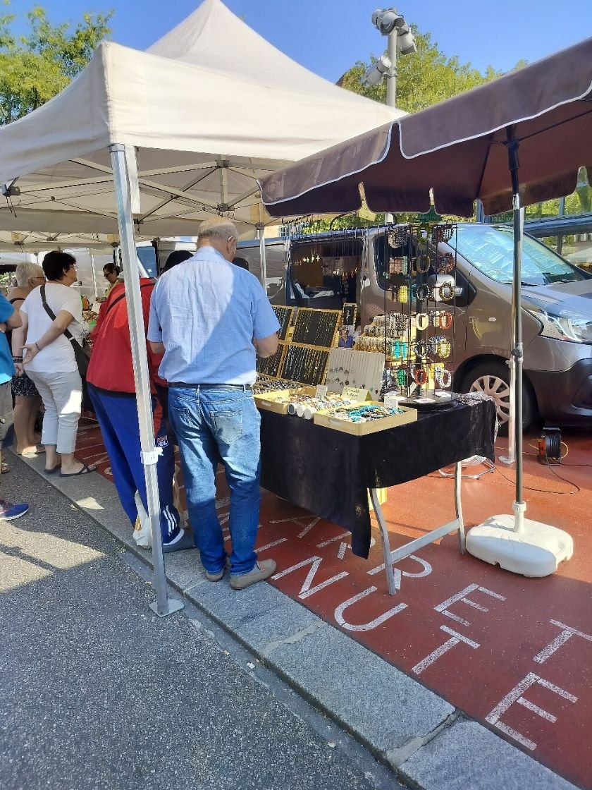 Un étal de marché vendant des bijoux et accessoires, personnes regardent les articles, photo gratuite