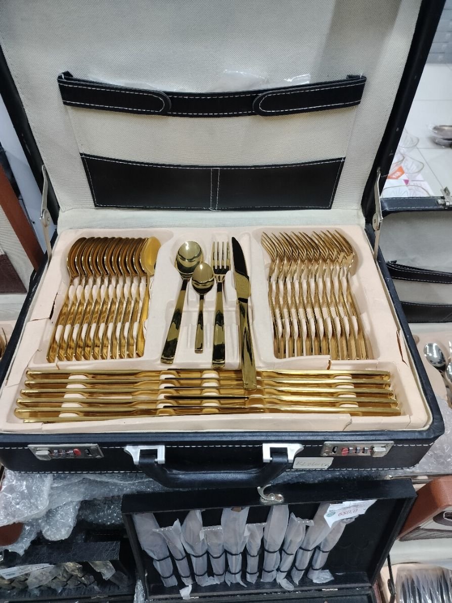 Un coffret de couverts de table, spécifiquement un ensemble de couverts plaqués or, photo gratuite