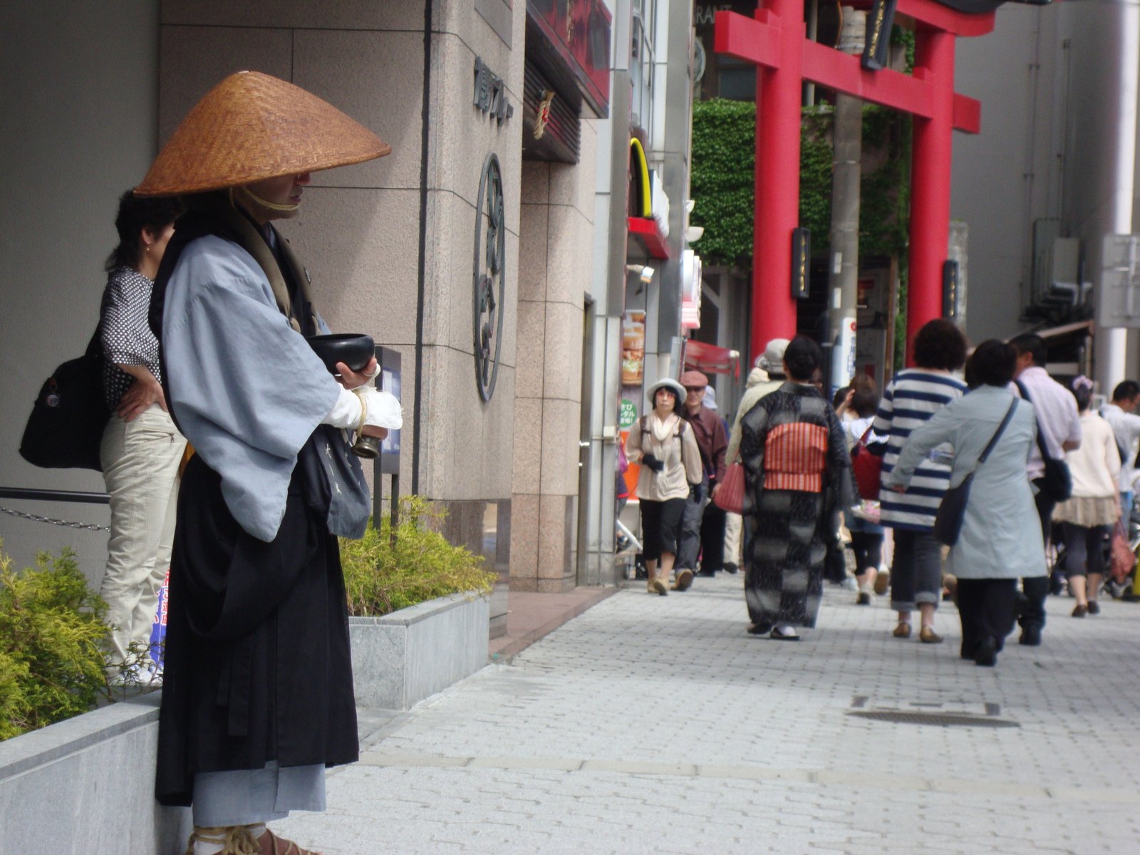 Passersby in traditional Japanese clothing in front of a red Torii gate free photo