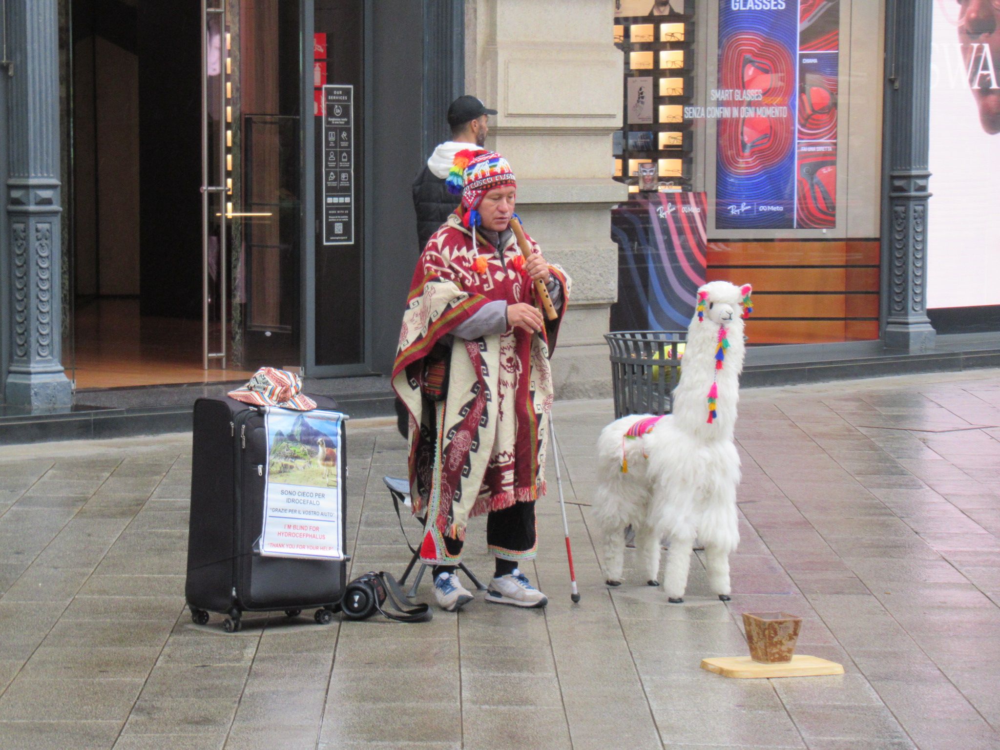Street musician in traditional dress with a stuffed llama free photo