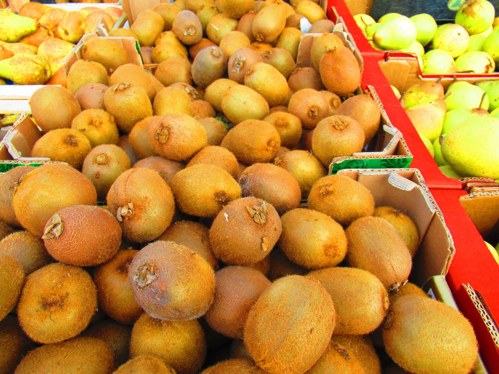 Des kiwis disposés dans des caisses sur un étal de marché photo gratuite
