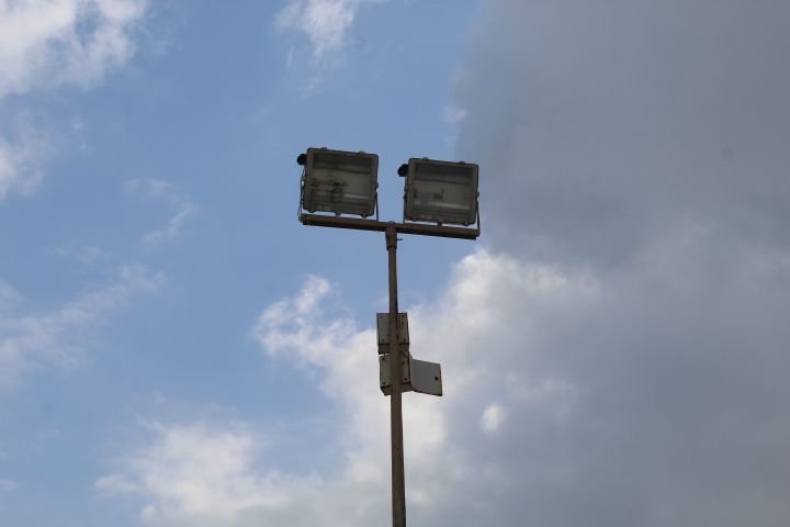 Projecteurs sous un ciel nuageux : éclairage public photo gratuite