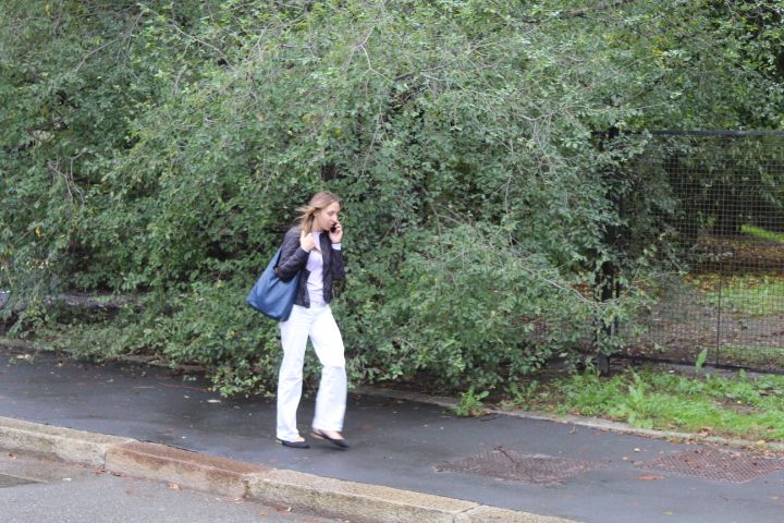 A woman talking on the phone on a sidewalk free photo