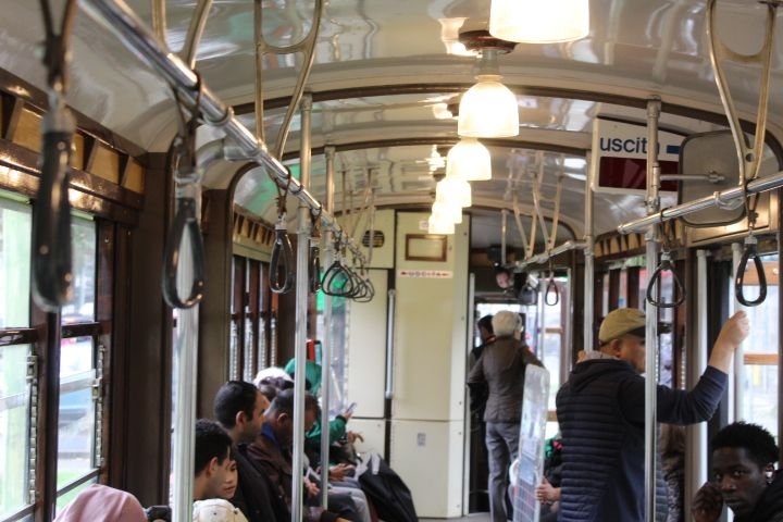 Personnes au bord d'un tramway, transport commun, en déplacement dans la ville de Milan Lombardie en Italie photo gratuite