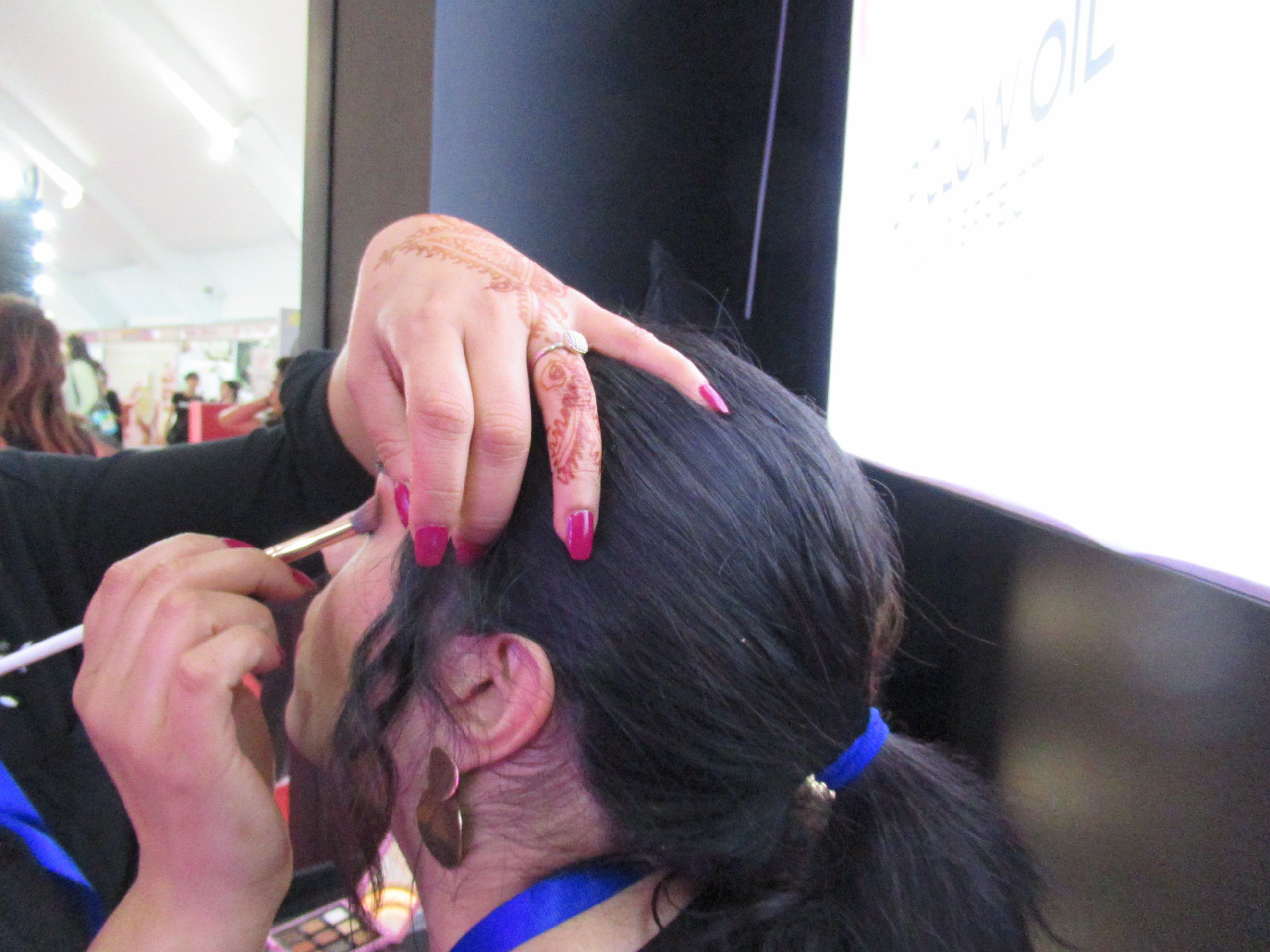Professionnelle maquillant une femme dans un salon de beauté