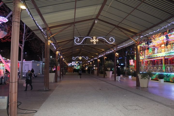 Illuminated night market under a tin roof free photo