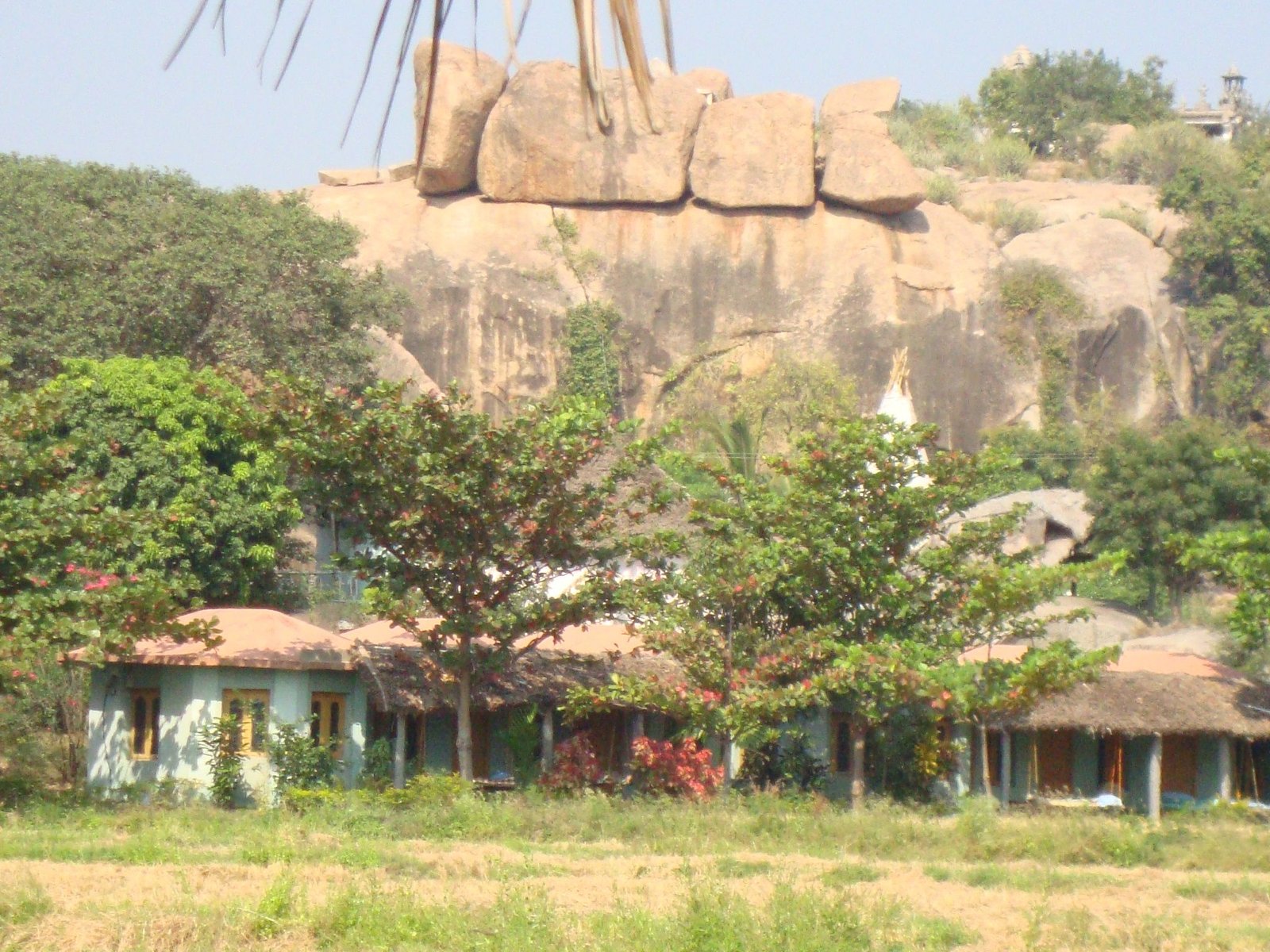 Un paysage à Hampi, batiment en dessous d'une formation rocheuse, photo gratuite