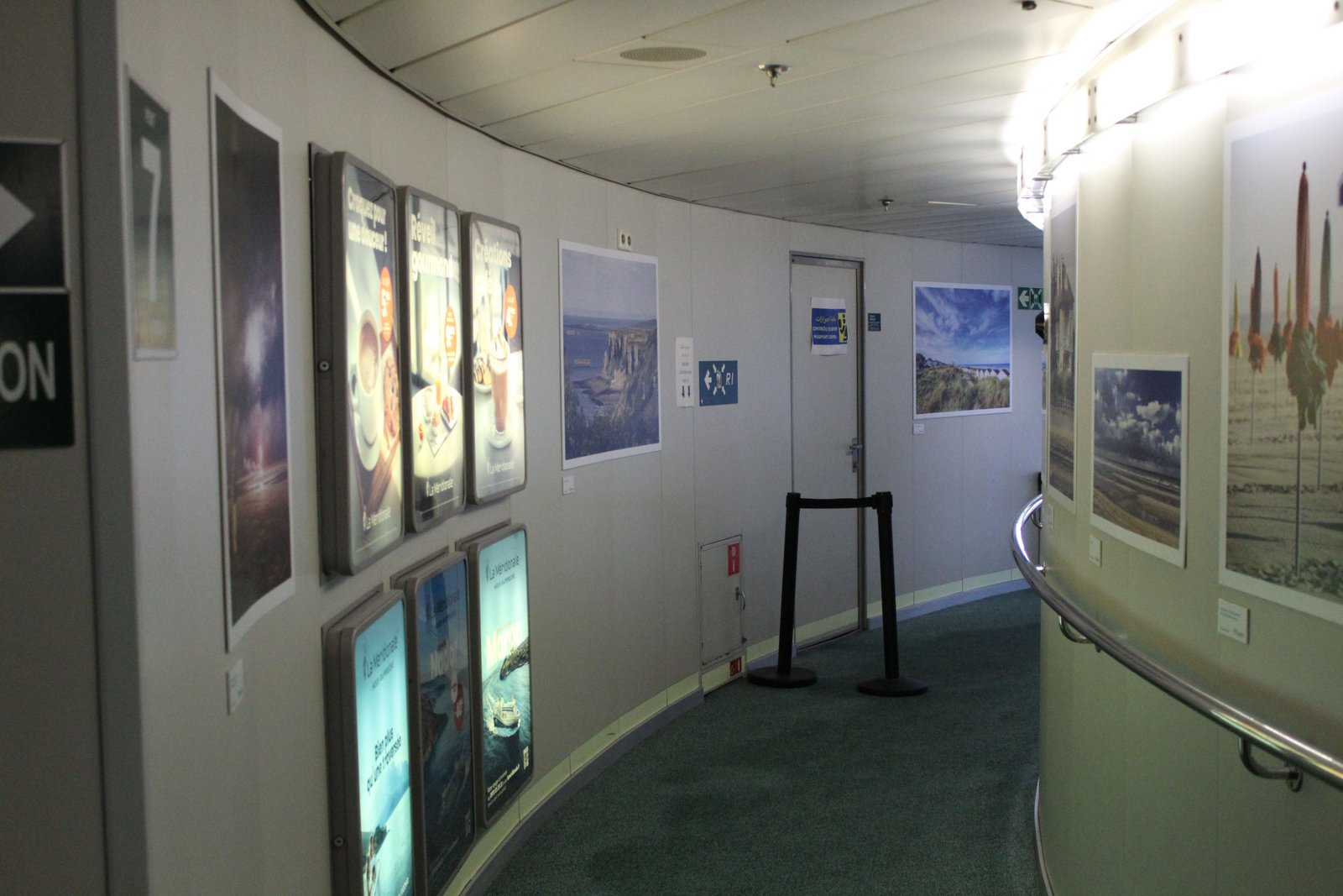 Un couloir à l'intérieur d'un bateau avec des affiches murales, photo gratuite