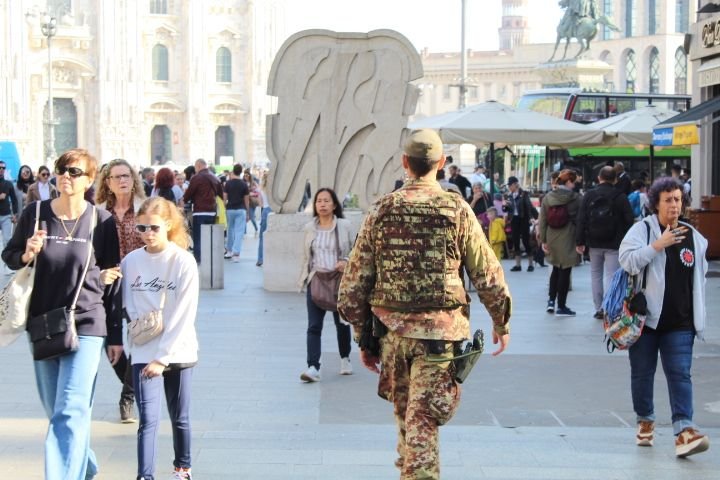 An Italian army soldier walks through the city, among civilians, free photo