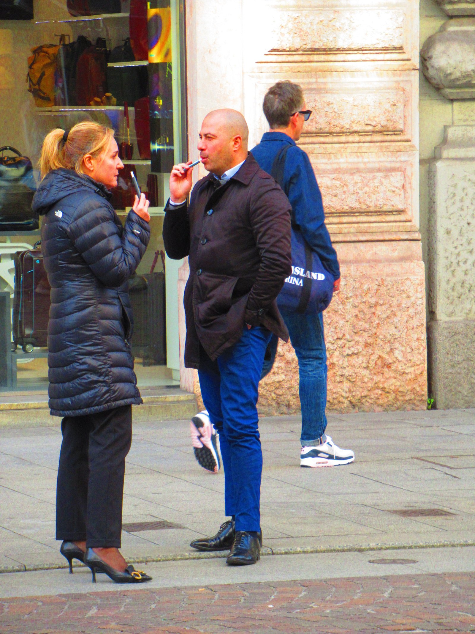 Two people smoking and talking in the street free photo