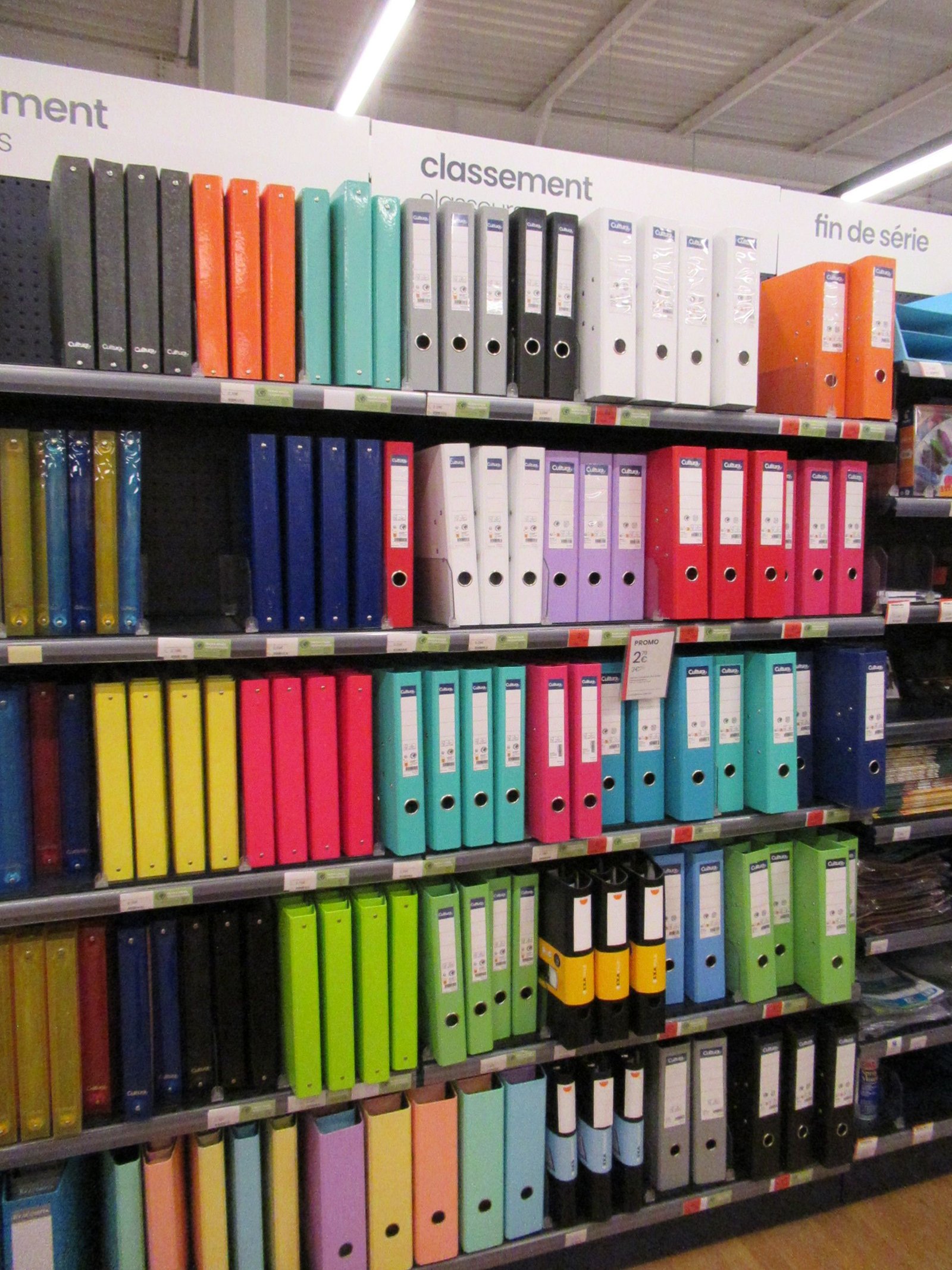 Alignement de classeurs à levier multicolores sur les étagères d'un magasin