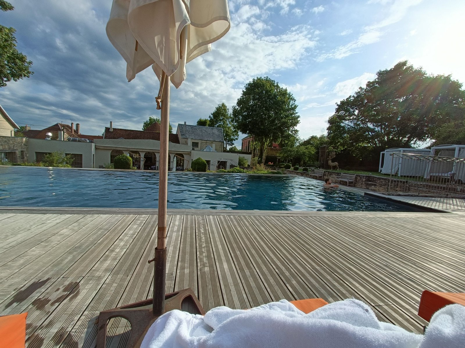Une piscine avec une terrasse en bois, photo gratuite