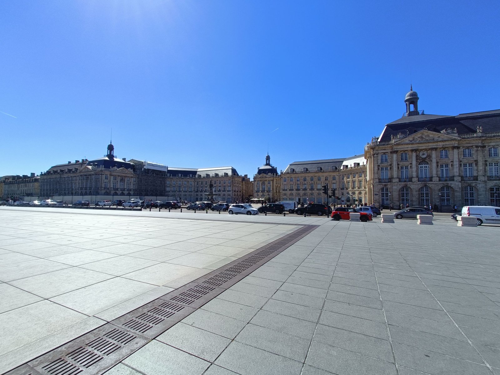La place de la Bourse et le Miroir d'eau à Bordeaux, en France, des voitures devant les bâtiment, photo gratuite