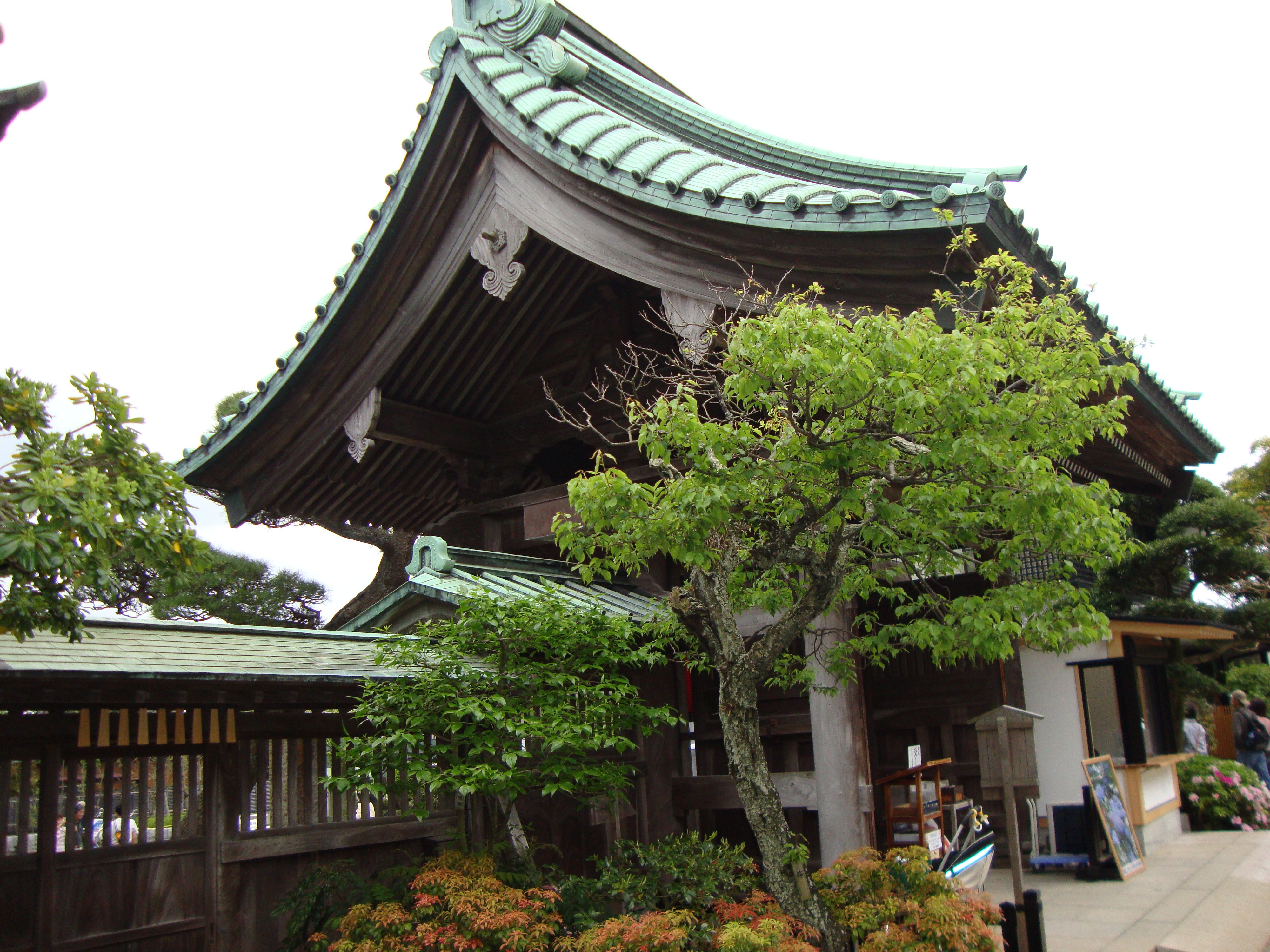Japanese temple with an imposing green roof surrounded by trees free photo