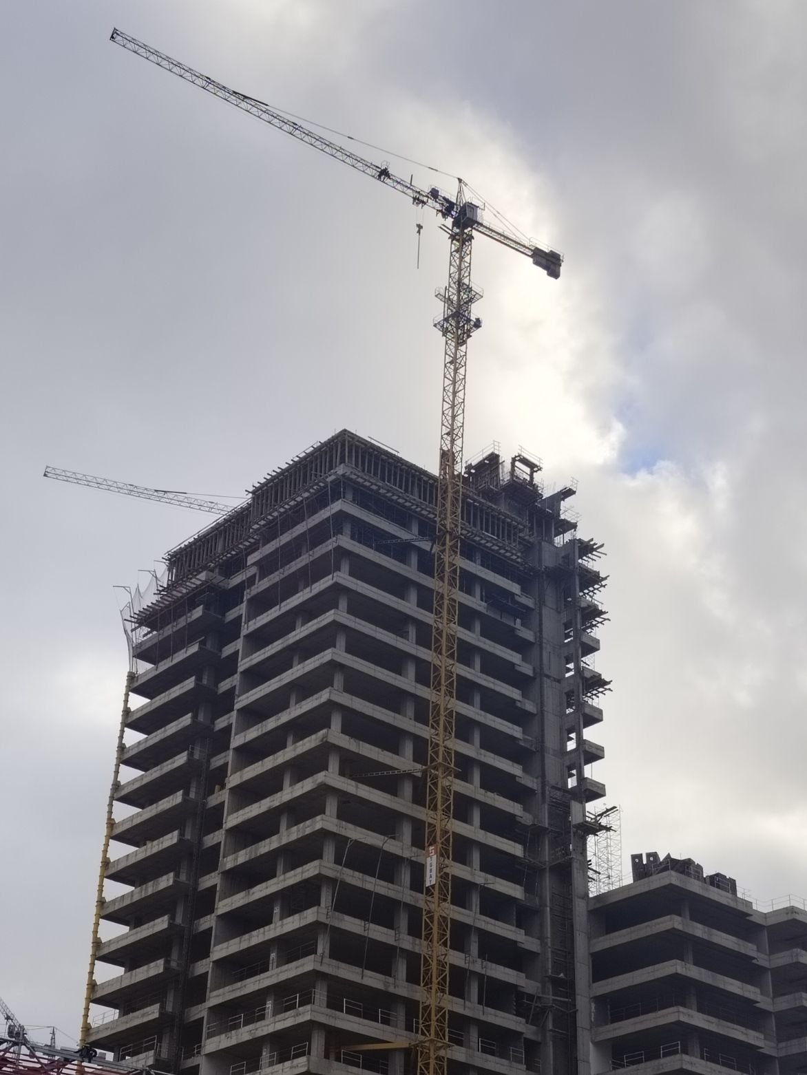 Un grand immeuble en construction avec une grue à tour à côté, photo gratuite