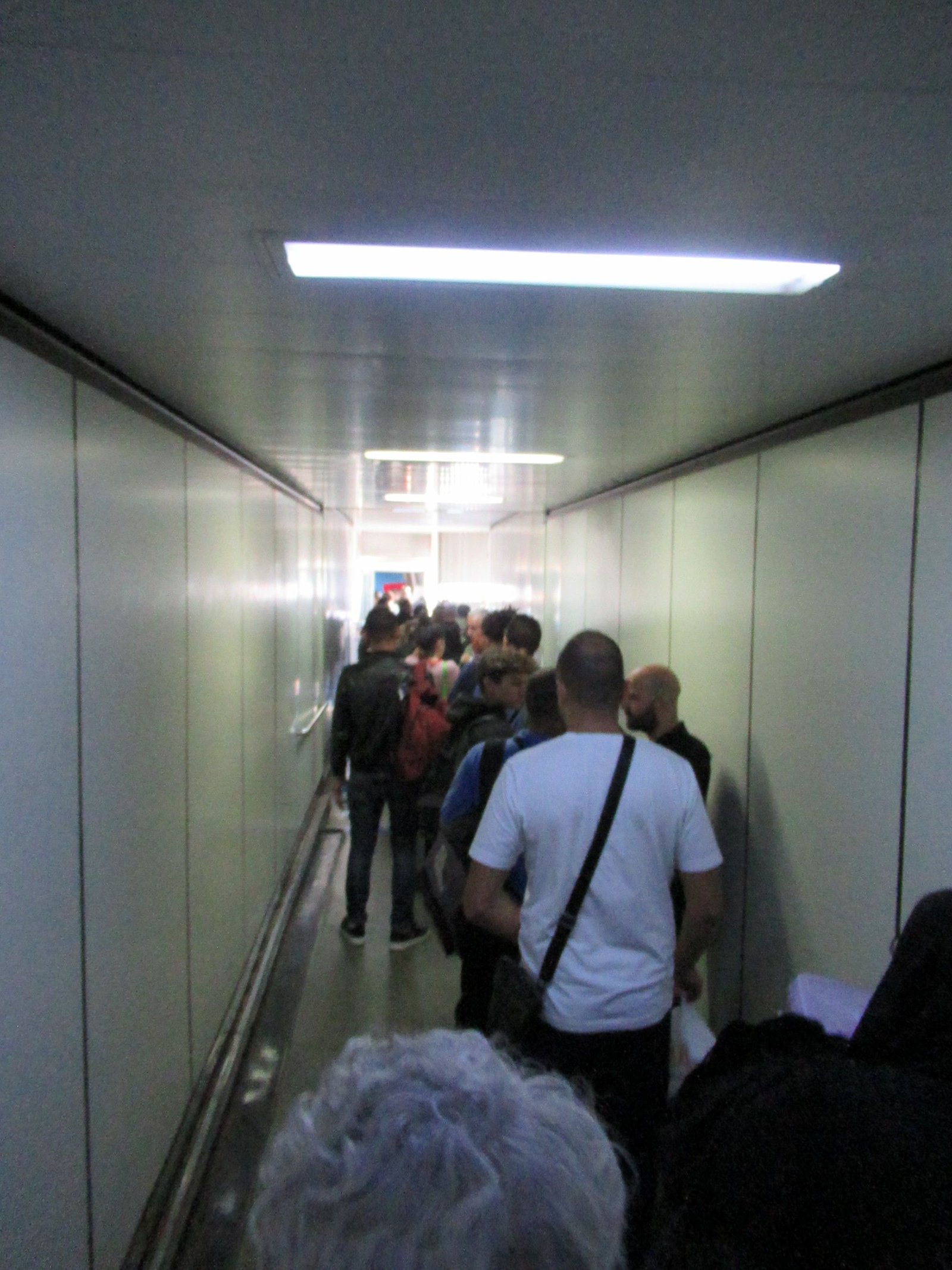 Passagers traversant une passerelle d'embarquement à bord d'un avion