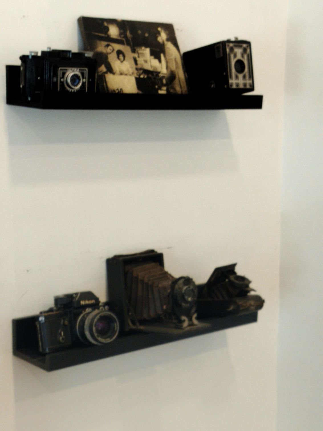 Une collection d'objets photographiques anciens exposés sur des étagères murales, photo gratuite