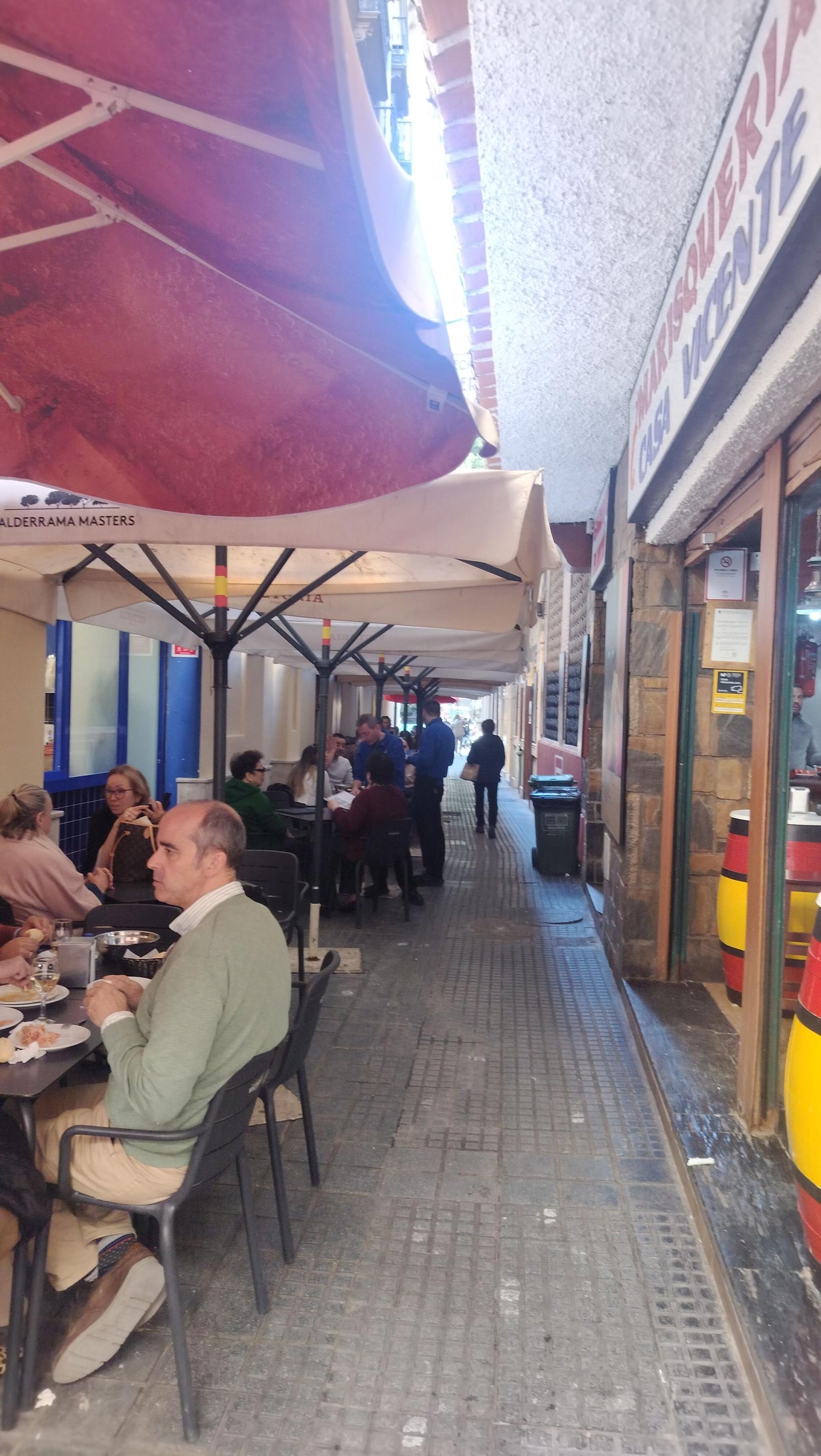 Des personnes assises à des tables de restaurant sous des parasols, photo gratuite