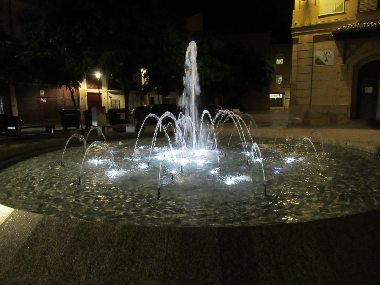 Une fontaine moderne illuminée la nuit, photo gratuite