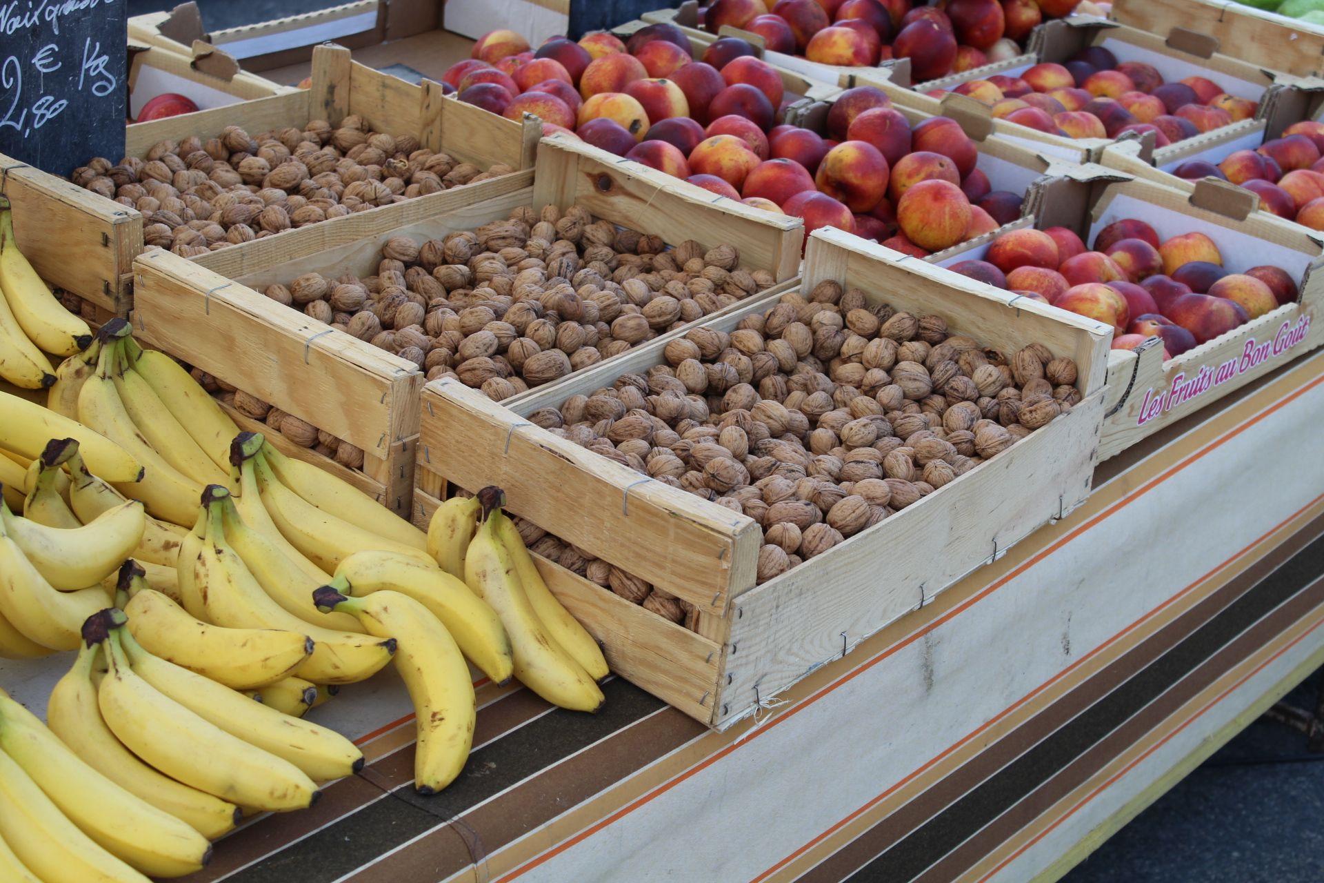 Étale de fruits : bananes - noix - brugnons