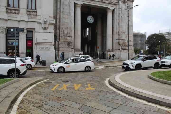 Des voitures taxis circulant dans la villde Milan Lombardie en Italie photo gratuite