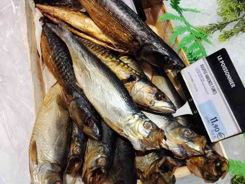 Poissons harengs fumés dans une boîte en vente dans un marché photo gratuite