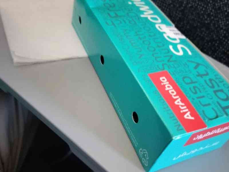 Boite en carton d'un sandwich Air Arabia sur une tablette photo gratuite