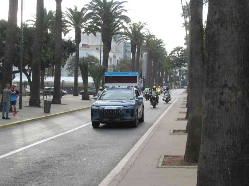 Un véhicule participant au marathon, suivi des motos, photo gratuite