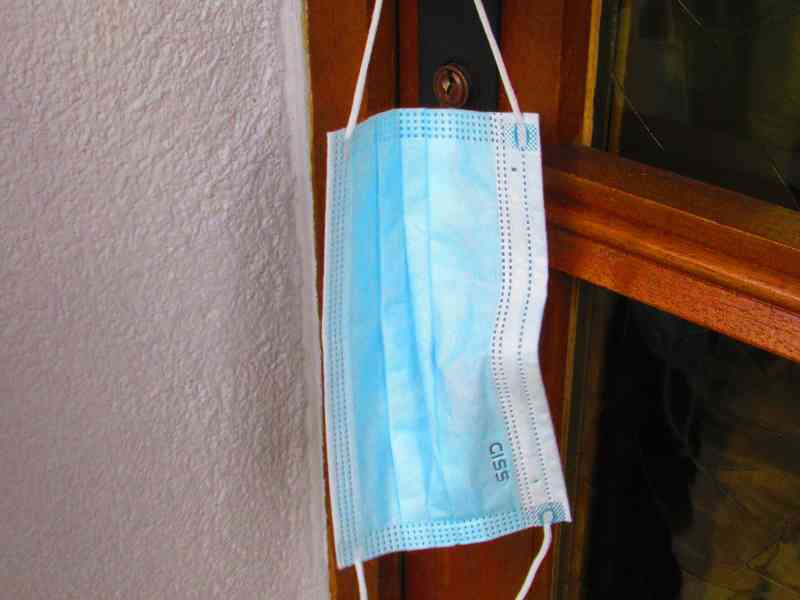 Sanitary mask hanging on a door handle