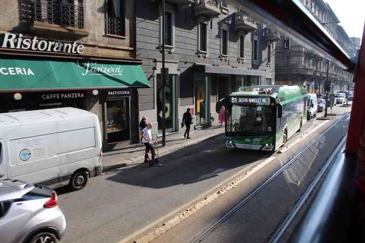 Une scène de rue animée, on voit des bâtiments, le restaurant Ristorante Janzera, des véhicules et des personnes, photo gratuite