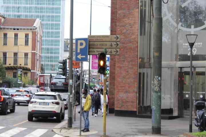 Une scène de rue urbaine en Italie, on y voit des voitures, les panneaux de signalisation et des individus, photo gratuite