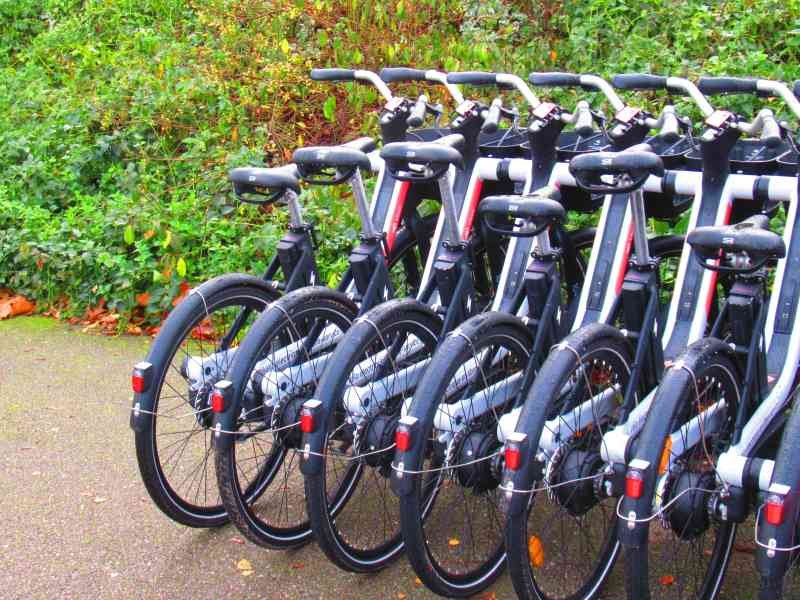 Des vélos électriques garés au bord d'une route, photo gratuite