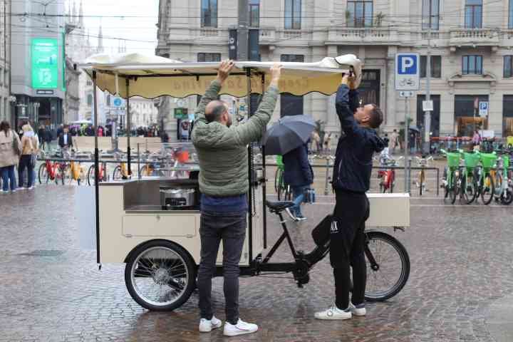 Deux personnes devant un vélo-cargo aménagé en stand de nourriture mobile, souvent appelé food bike, photo gratuite