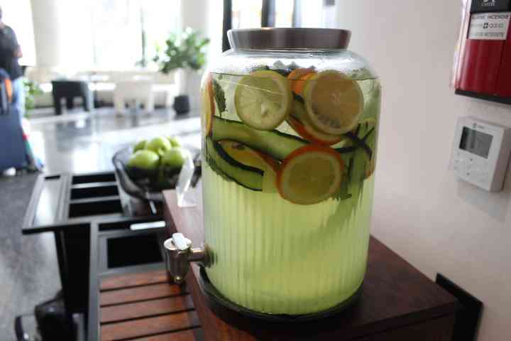 Un grand distributeur de boisson en verre rempli d’eau infusée aux fruits et légumes photo gratuite